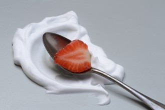 Strawberry with cream on a spoon