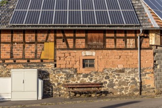 Historic farmhouse with photovoltaic system, solar panels on the roof, house wall with differently