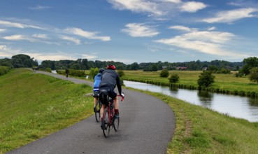 Cyclist on a cycle path by the river, landscape in the Lower Oder Valley National Park, Criewen,