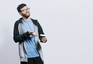 Smiling man showing coffee on isolated background. Guy pointing disposable cup of coffee isolated