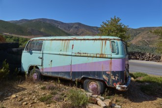 Rusty old van in hilly landscape under a bright blue sky, wrecked vehicle, Crete, Greek Islands,