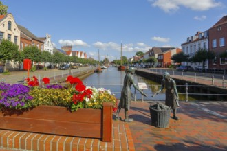 Old harbour with the bronze sculpture 'Törfwieven' in Weener, East Frisia, Lower Saxony, Germany,