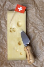 A piece of Swiss Emmental cheese and the Swiss flag