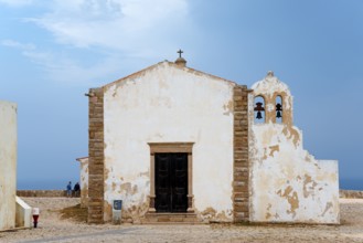 A historic chapel with bell tower and views of the ocean, surrounded by ancient walls, Igreja de