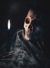 Skull with traces of blood and cobwebs, next to a candle in a dark environment