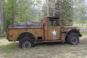 Side view of a rusty military vehicle with star in the forest, former army camp, Yukon, Discovery