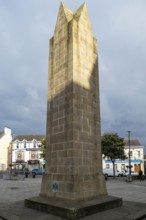 Large obelisk in a square with historic buildings in the background, Donegal