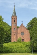 An impressive brick church with tower, embedded in green nature, Rügen