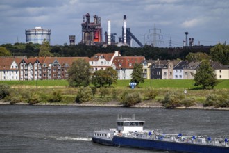 Cargo ship on the Rhine near Duisburg-Laar, houses on Deichstraße, industrial backdrop of the