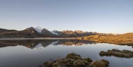 Glaciated mountain peaks reflected in a mountain lake at sunset, Arabel Lake at Arabel Pass, Issyk