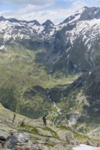 Mountaineer in front of picturesque mountain landscape, view of mountain hut Berliner Hütte with