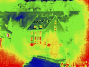 Apartment block, facade of a residential building with windows. Thermal image or thermography,