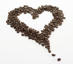 Coffee beans, arranged in a heart shape, on a white background