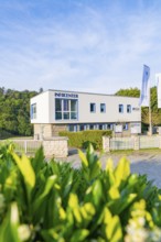 Modern information centre building with large glass windows and fences, surrounded by green nature,