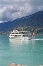 Large boat on a lake, forested mountains and clouds in the background, Lake Brienz, Switzerland,