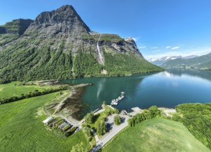 Aerial panoramic view over fjord Hjorundfjord, at village Oye, marina, waterfall, mt.