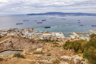 Panoramic view of a city by the sea with many ships and wooded hills, Gibraltar, Europe