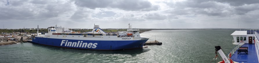 A Finnlines ferry at sea, surrounded by a cloudy sky and a distant horizon, Rosslare Harbour