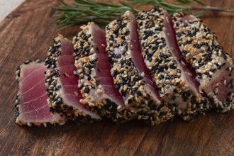 Fillet of red tuna meat, fried in sesame seeds, homemade, close-up, no people, on a wooden