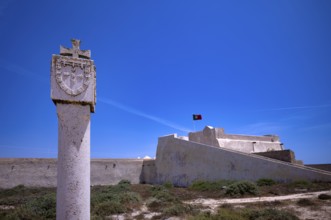 Memorial stone in honour of Henry the Navigator, Fortaleza de Sagres sea fortress, Portuguese flag,