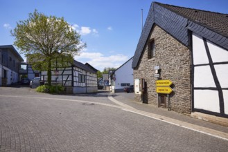 Street with half-timbered houses, sandstone buildings and signposts to Bad Münstereifel and