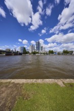 Skyline with riverbank, Main and skyscrapers under blue sky with cumulus clouds in Frankfurt am