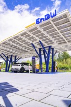 Modern EnBW charging station with solar roof for electric cars in a green environment, ENBW