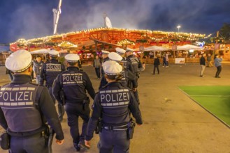 Police patrol at the Cannstatter Volksfest in the evening to ensure safety. It is one of the most