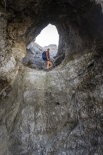 Hiker climbing through the Schindertor, Schinder, Tegernsee mountains in the Mangfall mountains,