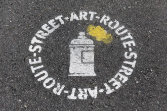 Street art route, stencil image on the asphalt as a signpost, urban art, Düsseldorf, North