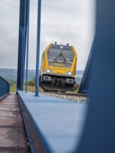 View of the front of a train near a blue bridge on rails, track construction, rail delivery for