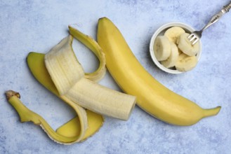 Opened banana and banana slices in peel