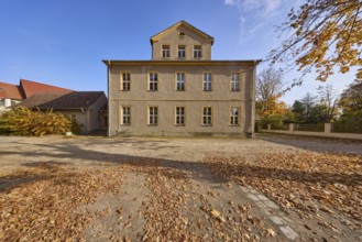 Two-storey building with pointed roof and dormer, autumnal trees and foliage, Schulplatz, Mühlberg