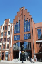 Modern brick building with large glass windows under a bright blue sky, Old Town Hall, Elblag,