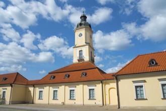 Historic building with clock tower and red roof tiles under a clear sky, town hall, museum,