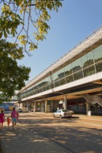 Modern railway station with glass facade, surrounded by trees, on a sunny day, Fröttmaning