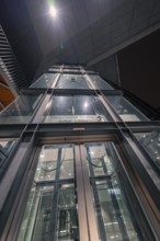 Modern glazed lift at night, integrated into the lighting of a building, Stuttgart, Germany, Europe