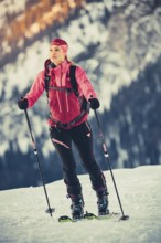 A woman's ski tour at sunrise on the Tegelberg in the Allgäu in the Ammergebirge, Bavaria, Germany,