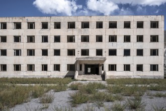 Entrance to an abandoned, destroyed residential building, old Soviet apartment blocks in the ghost