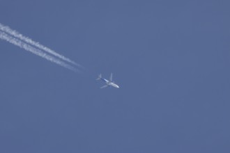 Boeing 737 jet aircraft of Jet 2 airlines flying in a blue sky with a vapor trail or contrail