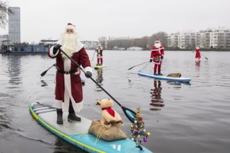 Water sports enthusiasts dressed as Santas ride SUPs on the Spree in Berlin on 14 December 2024