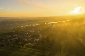 Aerial view, view of the village with St Michael's Church at sunrise, church casts a long shadow,