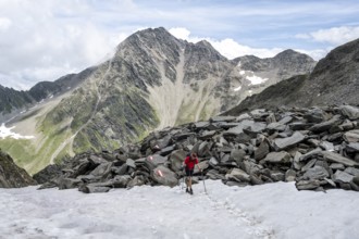 Hiker crossing a snowfield, Lasörling High Trail, Lasörling Group, Hohe Tauern National Park, East