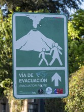 Signpost indicating evacuation route in case of a volcano eruption, Pucon, La Araucania, Chile,