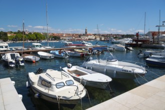 A busy harbour full of boats and yachts under a bright blue sky with a city view, Old Town, Krk