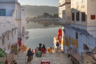 Morning atmosphere, people walking down to the lake shore, old town of Pushkar at the holy Pushkar