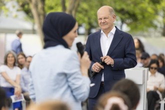 Olaf Scholz (Federal Chancellor, SPD) in conversation with a lady with a headscarf at the Germany