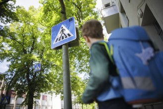 Symbol photo on the subject of schoolchildren in road traffic A six-year-old boy stands with his