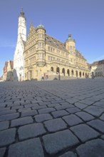 White town hall tower and Renaissance town hall, market square with cobblestones, view from below,