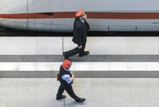 Deutsche Bahn service staff walk along an ICE train on the platform, 26/09/2016